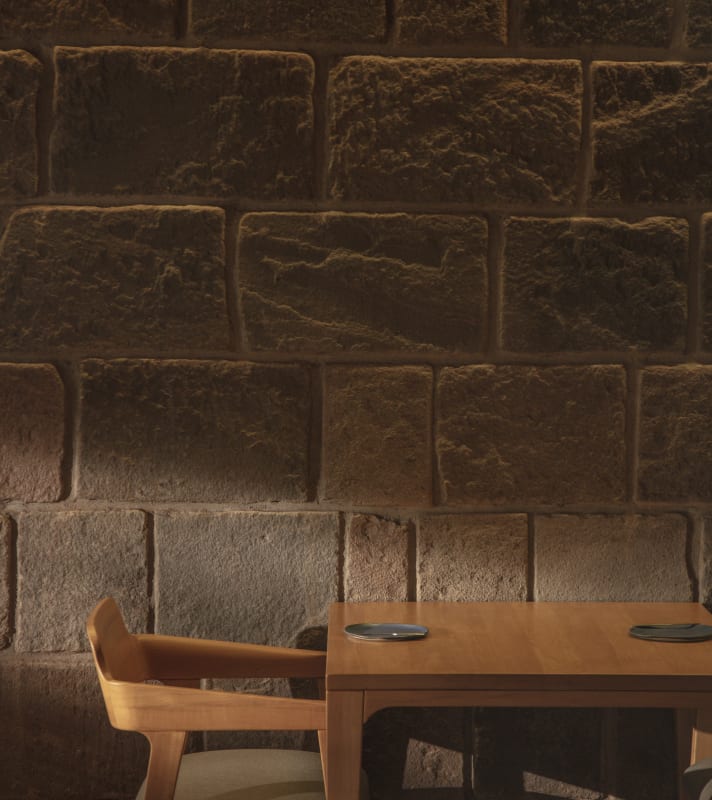 table and chair by stone wall