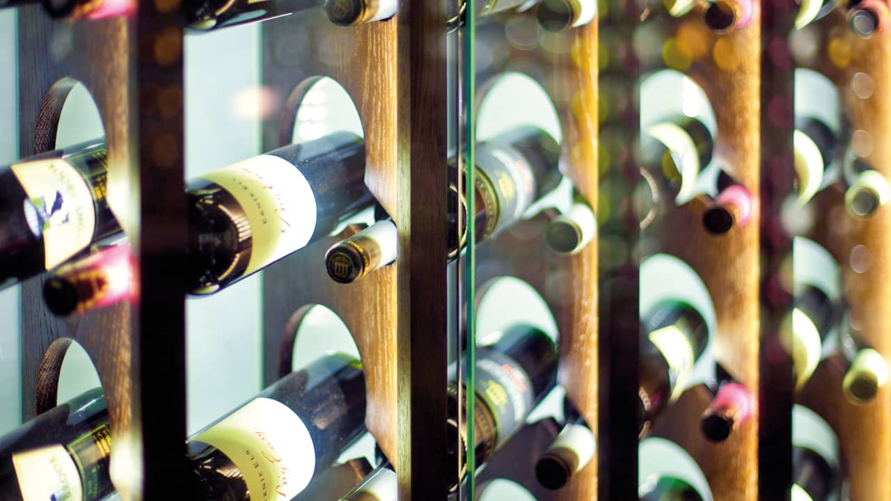 Glass fronted wine cellar with rows of bottles