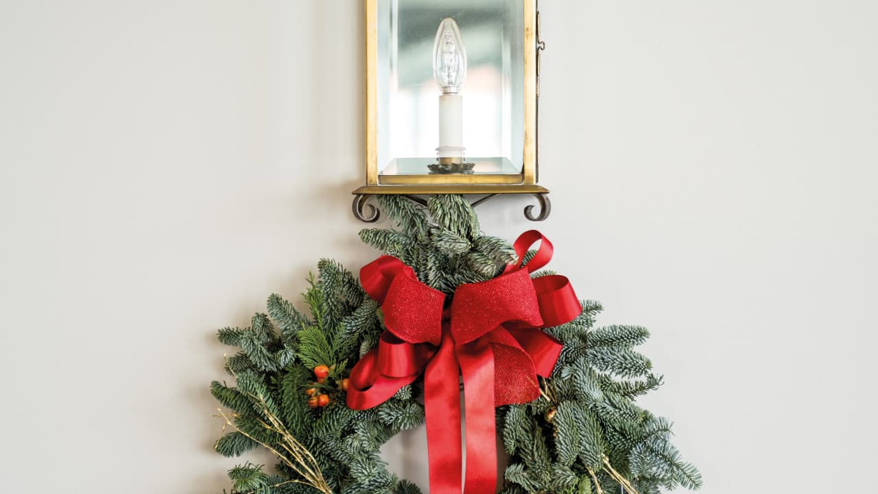 a christmas wreath hanging against a while wall
