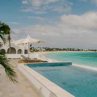 View of the white, sand-fringed sweep of Maundays Bay, with stunning turquoise waters, seen over the spa's infinity pool.