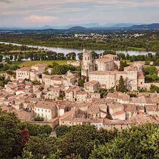 Aerial view of the terracotta roofs of Viviers, France, lush greenery surrounds with the river in the distance