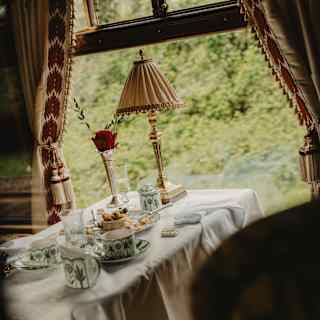 Angled image of a finished Afternoon Tea with tartlet crumbs and tea, served in William Edwards Sultan's Garden crockery.