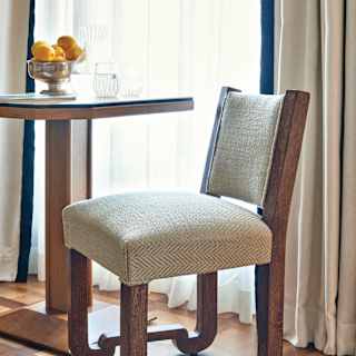 Close-up of a herringbone Italian knit chair at a table with a lemon centrepiece