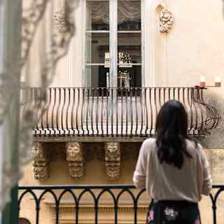 Lady at a Juliet balcony gazing across to a Juliet balcony opposite
