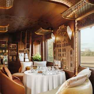 A brown tub chair and two yellow leather seats circle a white-clothed table with crystal glasses in L'Observatoire's lounge.