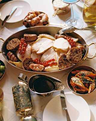 A festive feast of roast turkey with carrots, parsnips, sprouts and gravy, enjoyed with Christmas crackers, seen from above.