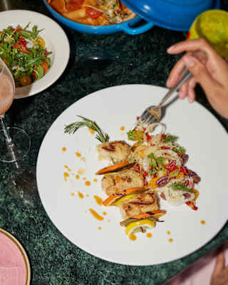 Looking down on a dish of Pesce Spada Siciliana, with breaded swordfish, fennel, oranges and olives, at Cip’s by Cipriani.