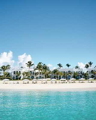 Beachfront villas on platinum sands viewed from across the water