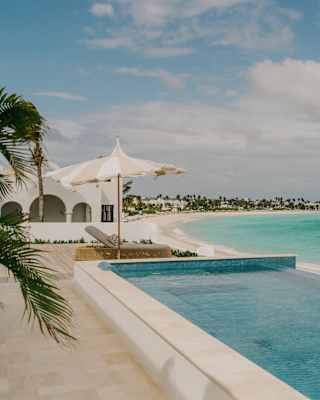 View of the white, sand-fringed sweep of Maundays Bay, with stunning turquoise waters, seen over the spa's infinity pool.