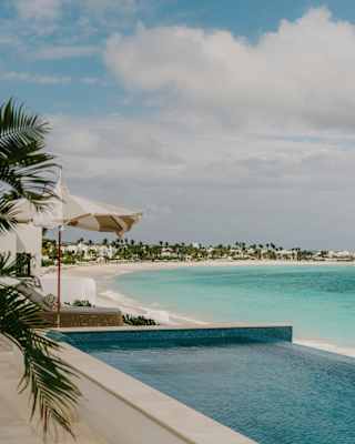 Shade cools the spa's infinity pool, which looks over the sun-kissed white sand and turquoise waters of Maundays Bay.