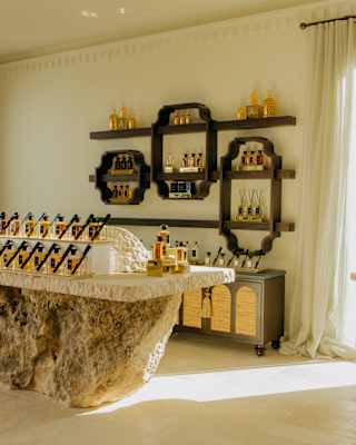 View over the cool interior of the Spa by Guerlain retail boutique, where a rock and stone plinth holds a neat display of bottles.
