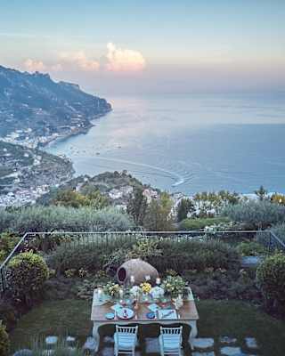 A private garden set with dinner for two enjoys spectacular views of the valley as it falls away down to Amalfi and the sea