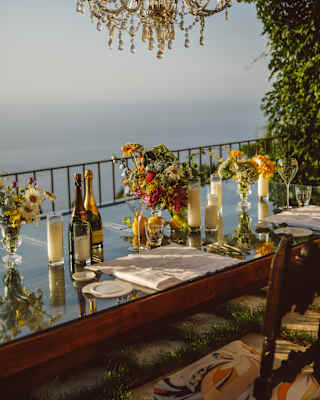 With champagne bottles, candles, flowers and a terrace chandelier, the Krug table offers a rustic yet extravagant experience.