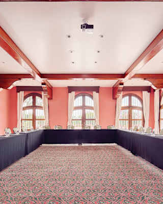 Large pink room with conference tables in a U-formation