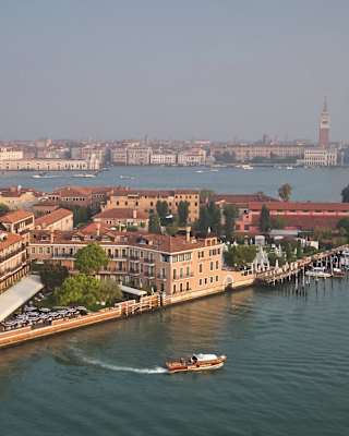 The Hotel Cipriani’s launch leaves a wake as it pulls away from the private dock. Behind, the iconic pink walls stand majestic