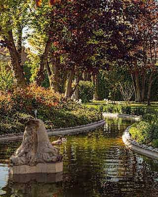 A stone, double-headed animal water feature adds romance and intrigue to the pond in Hotel Cipriani's Casanova Gardens.