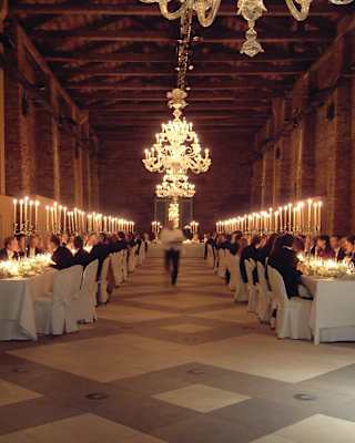 Interior of a brick granary with a grand chandelier and banquet tables lining the sides