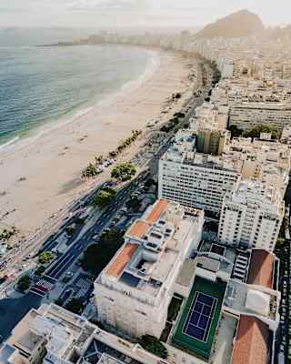 The wide sweep of Copacabana Beach with Rio's high-rise blocks and mountains to the right, white sand and sea to the left