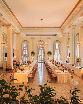 Art deco ballroom with two long banquet tables set for a wedding