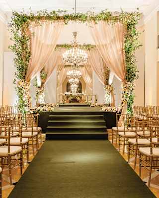 In the Visitor's Room, a green carpet flanked by chairs follows steps up to a platform with flowers, drapes and a chandelier.