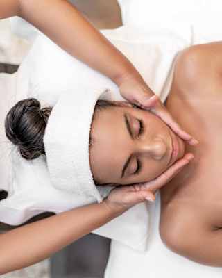 Birds-eye-view of a lady on a massage table enjoying a facial spa treatment