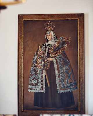 Close-up of a portrait of a regal woman wearing a cloak and floral crown