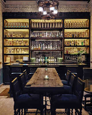 Elegant bar area with rows of tequila bottles on mirrored shelves