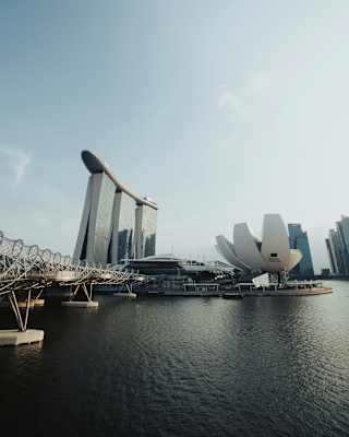 The flower-like ArtScience Museum and the imposing three-towered Marina Bay Sands hotel in Singapore, viewed from the bay.