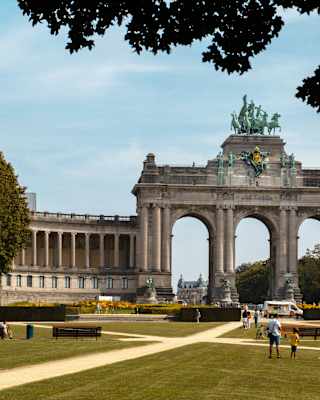 View over the Parc du Cinquantenaire to the triumphal Arch, with a female charioteer sculpture, flanked by colonnades.