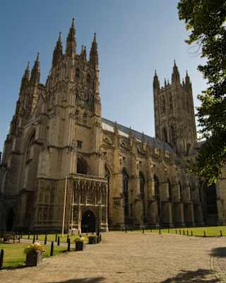 Stone path leading to an ornate medieval sandstone cathedral under blue skies