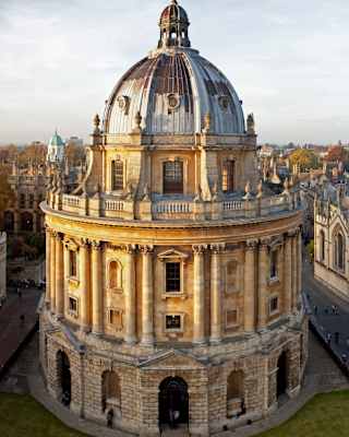 View from above of Oxford's Radcliffe Camera Library and All Souls College, as the yellow-tinted stone glows in evening sun.