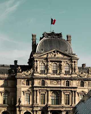 View of the Pavillon Richelieu wing of the Louvre Museum in Paris, France, part-obscured by the glass pyramid entrance.