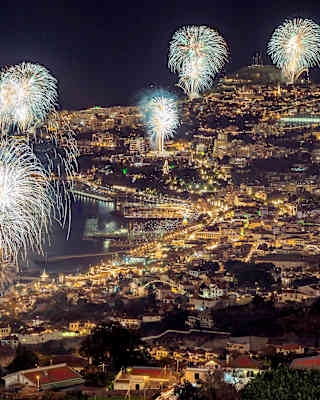 A collection of fireworks lighting up the night sky over Funchal Bay
