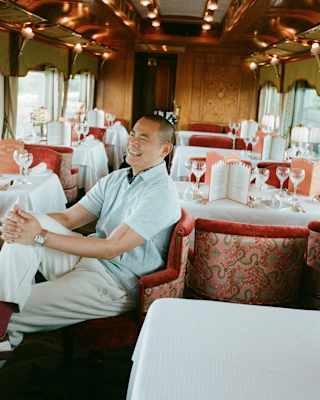 Chef André Chiang, in a blue shirt and white chinos, laughs as he sits casually in the Malaya dining car in a plush red chair.
