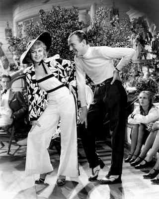 Black and white image of Ginger Rogers and Fred Astaire striking a pose in monochrome outfits in the film Flying Down To Rio.