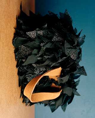 Close-up of a shopper bag in repurposed knotted black silk with tan leather strap, designed by Laani Raani.