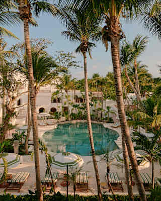 A ring of palms creates an oasis feel at Maroma's pool, which sits like a turquoise jewel in cream stone, seen from above.