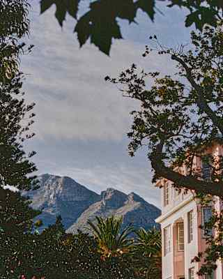The contours and ridges of the mountain ranges create dramatic scenery behind the manicured elegance of the hotel.