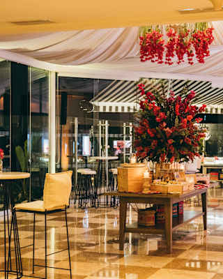 A huge starburst display of red blooms complements smaller bouquets hanging from the canopy drapes in tiled dining room.