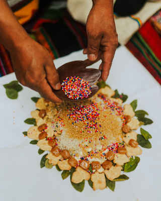 A shaman makes a beautiful offering of rice, biscuits and hundreds-and-thousands during an Earth Payment ceremony, close-up.