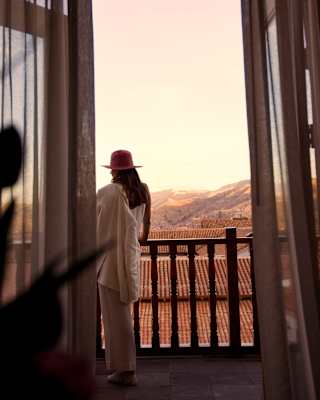 A woman standing on the balcony of the Palacio Suite