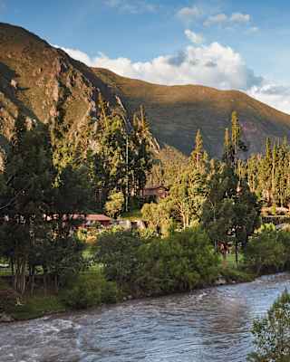 The Urubamba River winding through a mountainous valley under blue skies