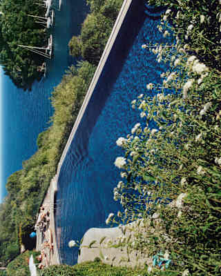 The deep blue of the hotel pool matches the deep blue of Portofino Bay behind as it opens out into the Mediterranean Sea