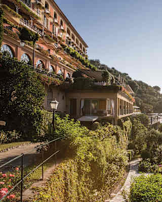 Classical Italian villa perched on a hilltop surrounded by lush Mediterranean gardens