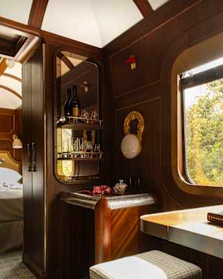 In a Grand Suite detail, views fill a window and reflect in the mirrored glass shelves set into a wood-panelled corner.
