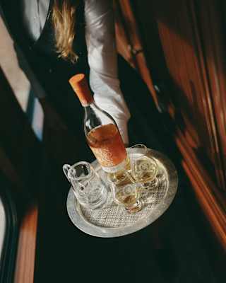 Close-up of a tray carrying a bottle of Glenmorangie single malt whisky with two whisky glasses and a jug of water.