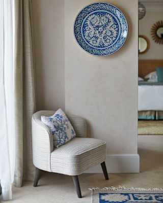 Close-up of a light-grey armchair with a blue floral patterned cushion