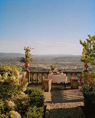A lunch table on a rustic terrace overlooking Florence bakes in heat and romance, taken by Photographer François Halard.