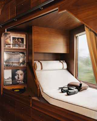 A selection of vinyl is kept neat in shelves adjacent to a window-side daybed where binoculars rest on the white mattress.