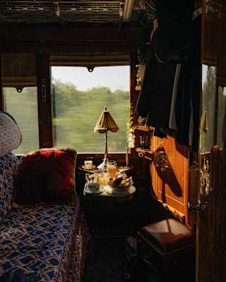 A wood cabin with upholstered banquette and a table of refreshments offers a luxury environment for watching the world go by.
